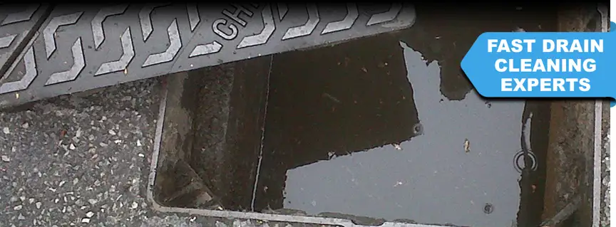 An open manhole cover showing a fully blocked drain in Midhurst – requiring urgent unblocking services