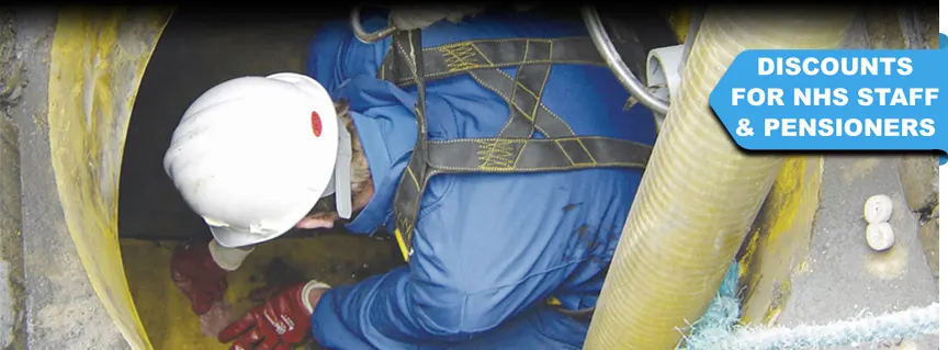 Worker in confined space repairing a blocked drain