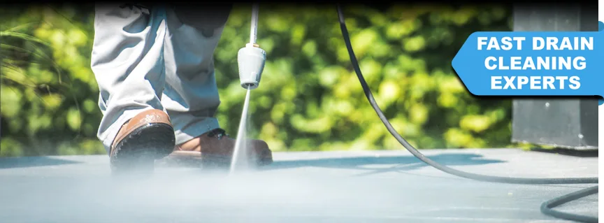 A DRAINTECH technician operating a high-pressure water jet