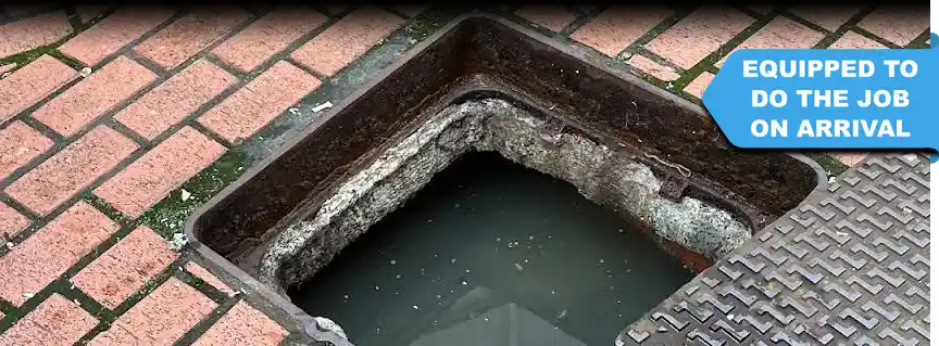 An opened manhole cover reveals a completely blocked drain, requiring expert drain unblocking services